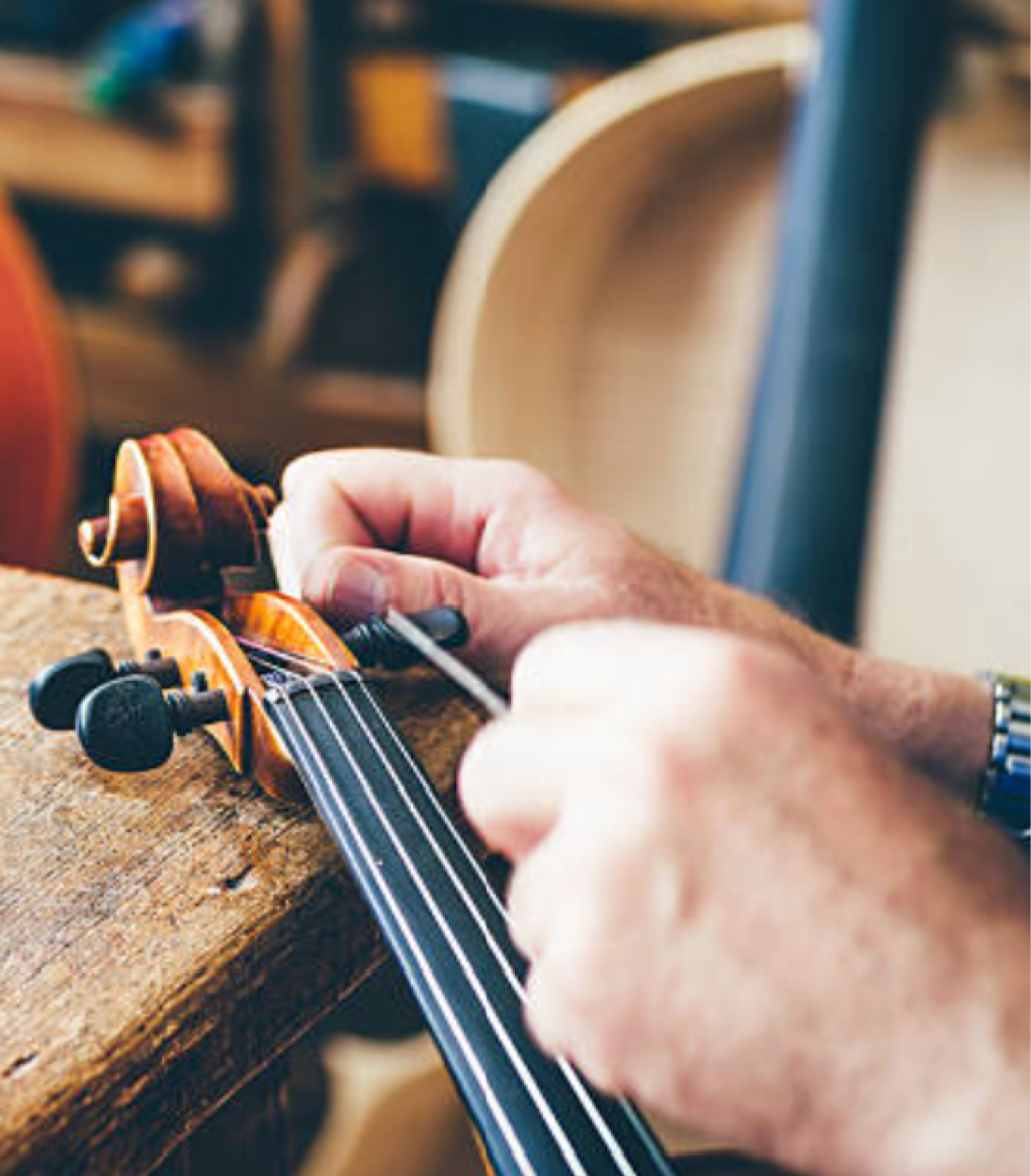 Tunepike NJ workshop technician inspecting a violin
